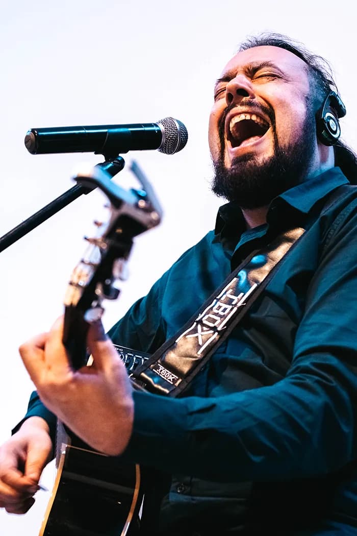 Diogo Barlete tocando violão no palco