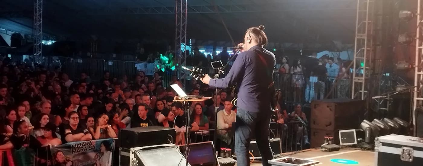Diogo Barlete tocando de costas para grande plateia